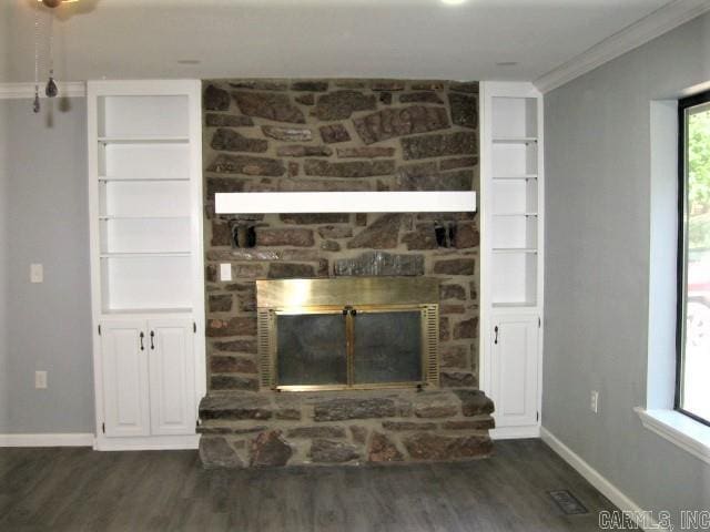 interior details with baseboards, a stone fireplace, wood finished floors, and crown molding