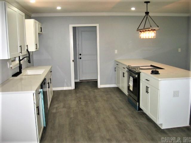 kitchen with electric range, a sink, a peninsula, crown molding, and light countertops