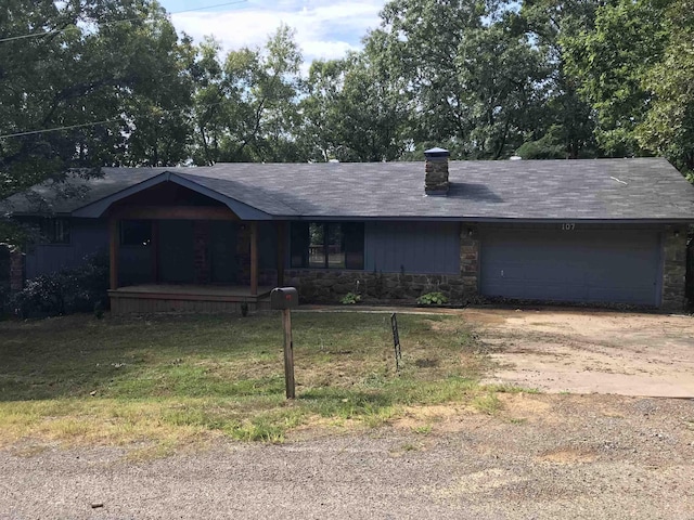 single story home featuring driveway, an attached garage, a chimney, a front lawn, and stone siding