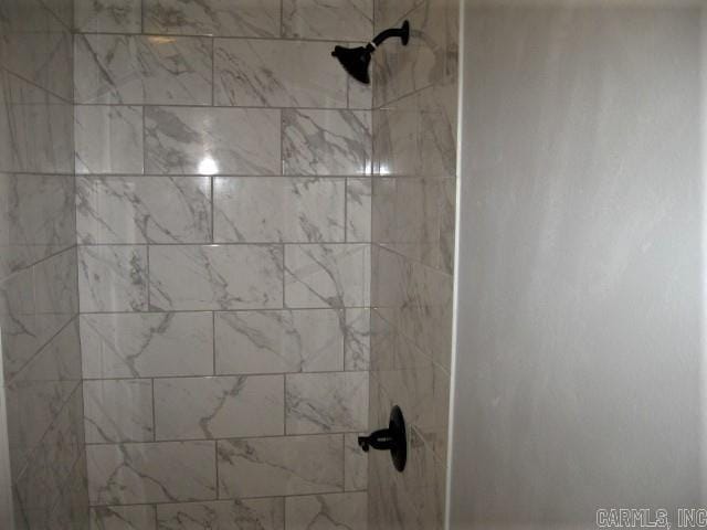 interior details featuring a tile shower