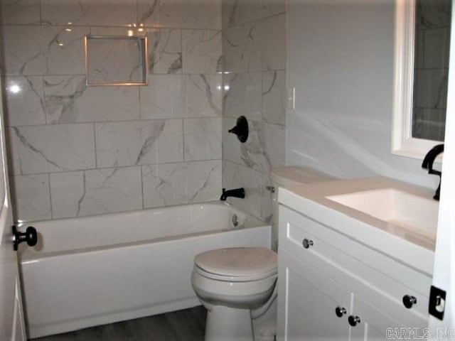 bathroom with washtub / shower combination, toilet, wood finished floors, and vanity