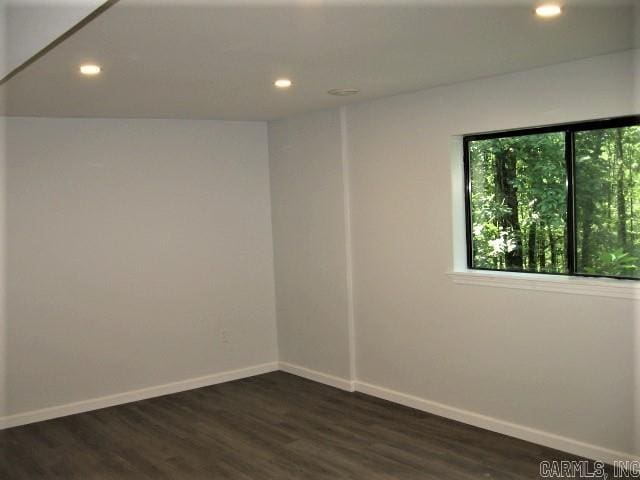 empty room with recessed lighting, baseboards, and dark wood-style floors