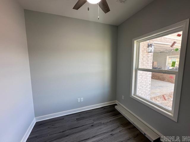 unfurnished room with dark wood-type flooring, a ceiling fan, baseboards, and visible vents