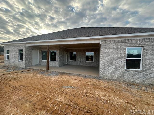 rear view of house with a patio and brick siding