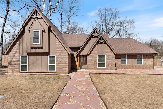view of front of house featuring board and batten siding, brick siding, and roof with shingles