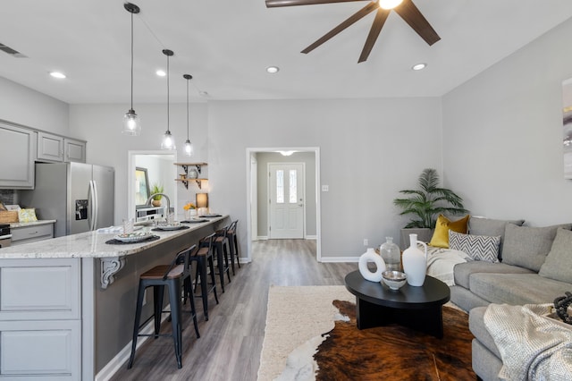 living area with light wood-style flooring, recessed lighting, and ceiling fan