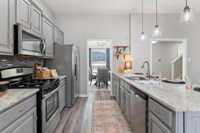 kitchen featuring a sink, backsplash, appliances with stainless steel finishes, and gray cabinets