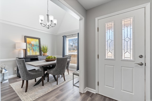 foyer entrance featuring baseboards, lofted ceiling, an inviting chandelier, and dark wood-style floors