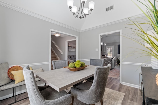 dining room featuring stairway, wood finished floors, visible vents, an inviting chandelier, and lofted ceiling