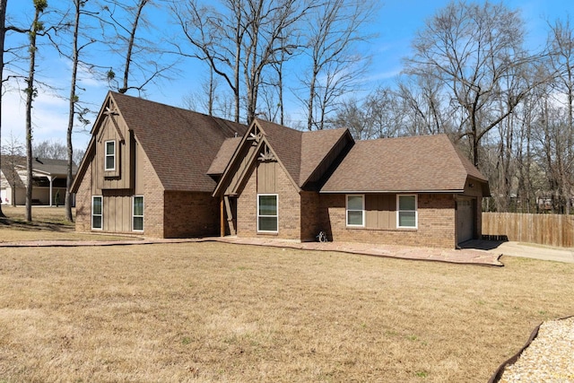 view of front of house with a front yard, brick siding, board and batten siding, and a shingled roof