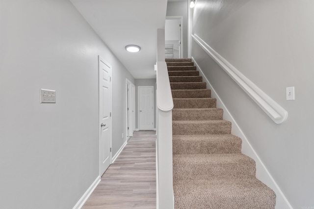 stairway with baseboards and wood finished floors