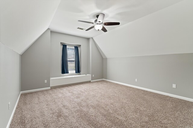 additional living space with visible vents, carpet floors, baseboards, ceiling fan, and vaulted ceiling