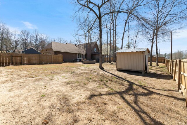 view of yard featuring an outbuilding, a storage shed, and a fenced backyard