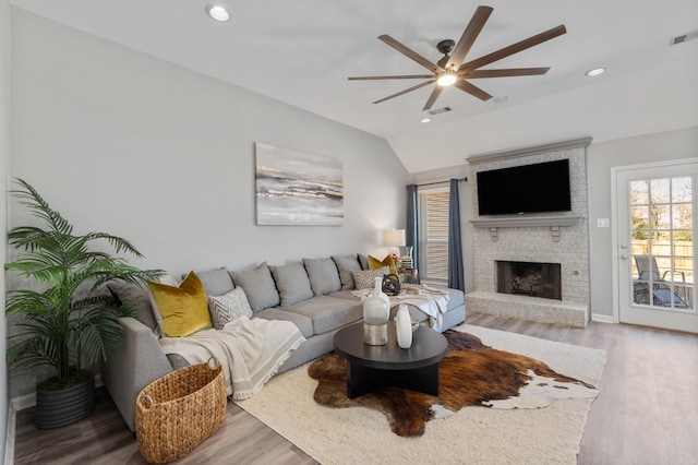 living room with wood finished floors, lofted ceiling, recessed lighting, a fireplace, and ceiling fan