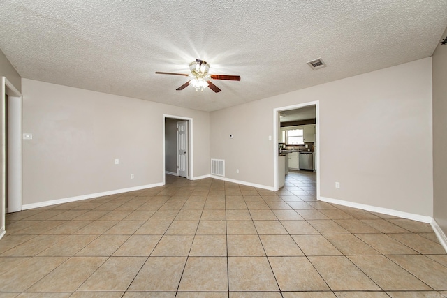 unfurnished room featuring visible vents, baseboards, ceiling fan, light tile patterned floors, and a textured ceiling