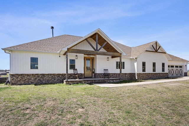 modern inspired farmhouse with a front yard, a garage, and a shingled roof