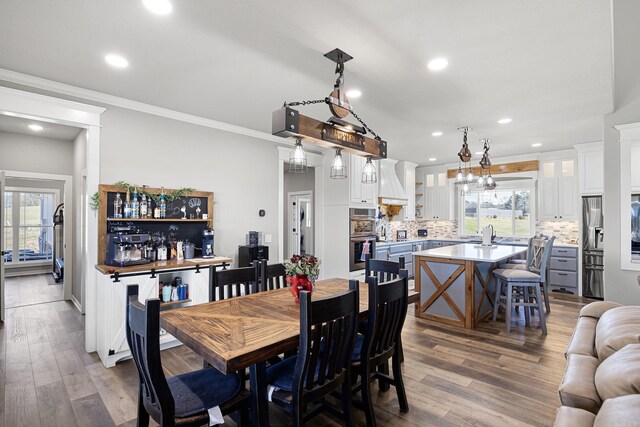 dining space with recessed lighting, dark wood-style flooring, and ornamental molding