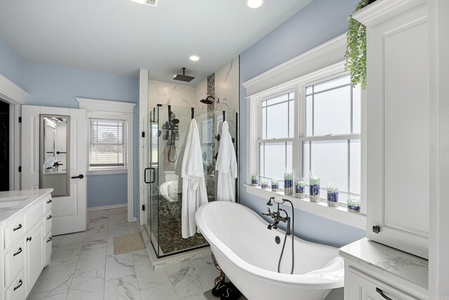 bathroom with recessed lighting, a stall shower, a freestanding tub, marble finish floor, and vanity