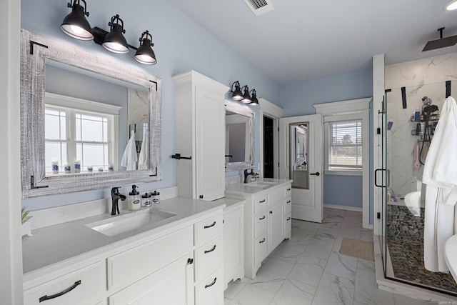 bathroom featuring visible vents, marble finish floor, a marble finish shower, and a sink