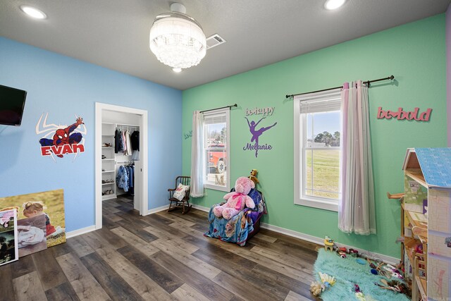 game room with a chandelier, visible vents, dark wood finished floors, and baseboards
