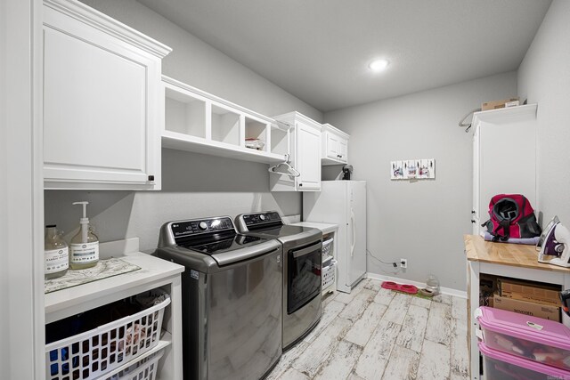 washroom featuring washer and dryer, recessed lighting, cabinet space, light wood-style floors, and baseboards