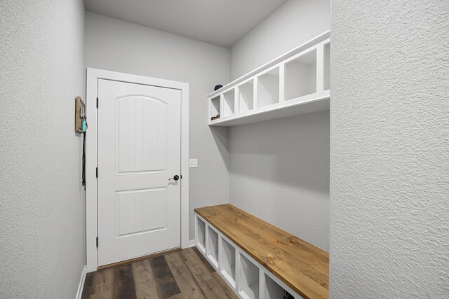 mudroom with baseboards, dark wood-style flooring, and a textured wall
