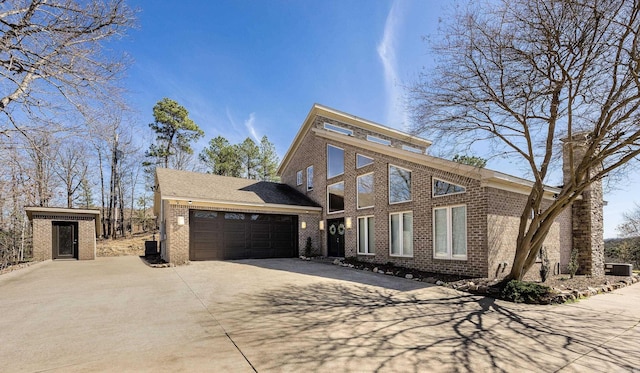 view of front facade with concrete driveway, brick siding, and an attached garage