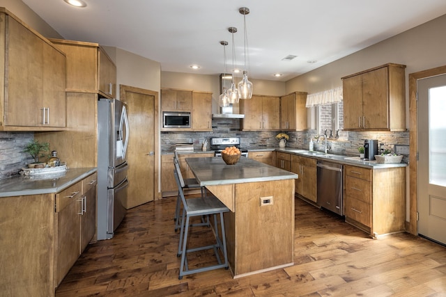 kitchen with tasteful backsplash, wall chimney range hood, a kitchen island, and stainless steel appliances