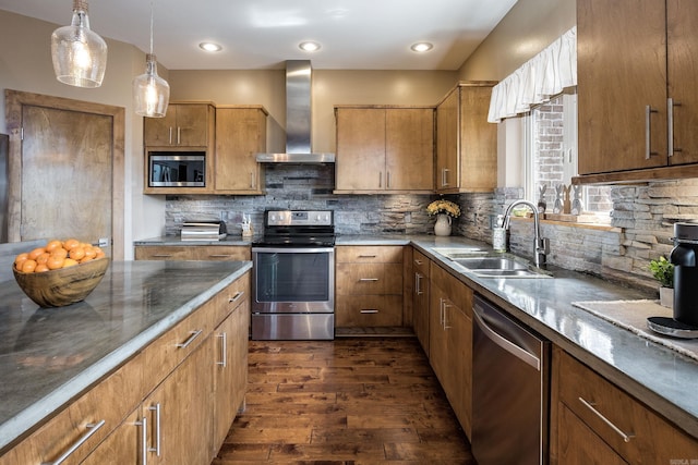 kitchen with tasteful backsplash, wall chimney range hood, appliances with stainless steel finishes, dark wood-style flooring, and a sink