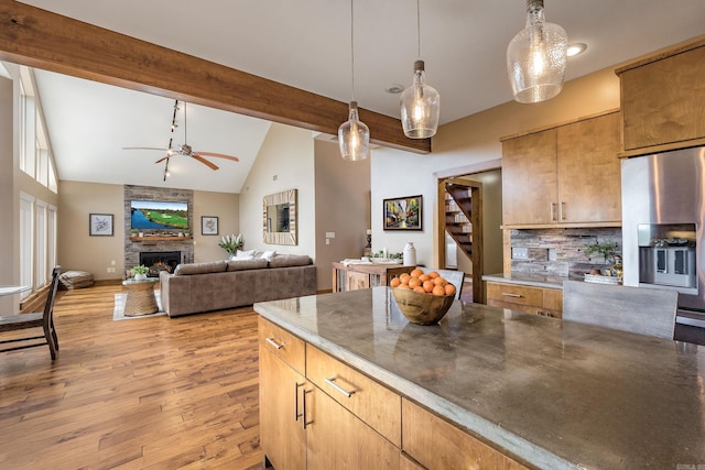 kitchen featuring beamed ceiling, light wood-style flooring, a ceiling fan, stainless steel fridge, and decorative backsplash
