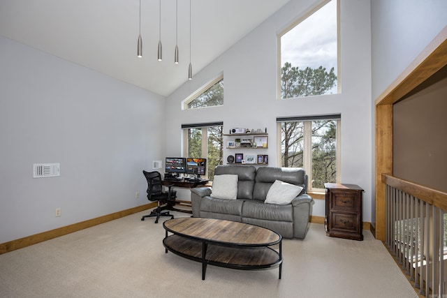carpeted living room featuring baseboards and high vaulted ceiling