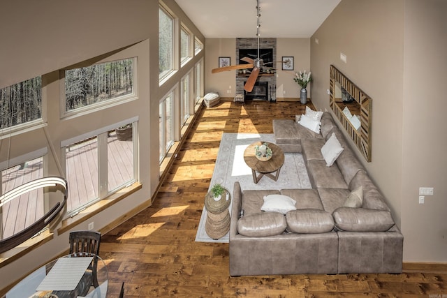 living room with ceiling fan, wood-type flooring, and baseboards