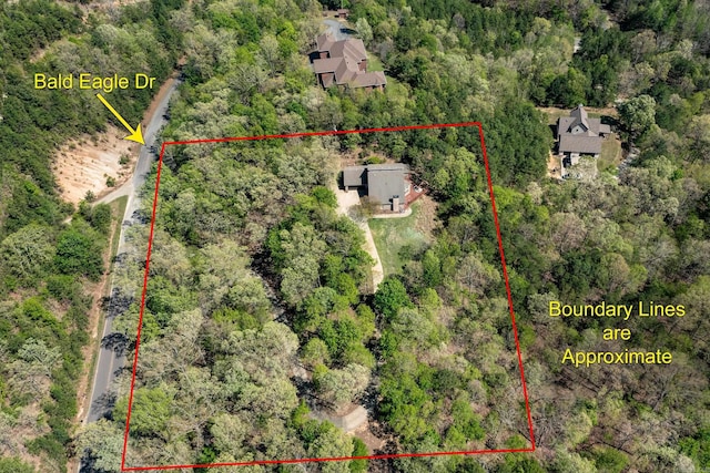 birds eye view of property featuring a view of trees