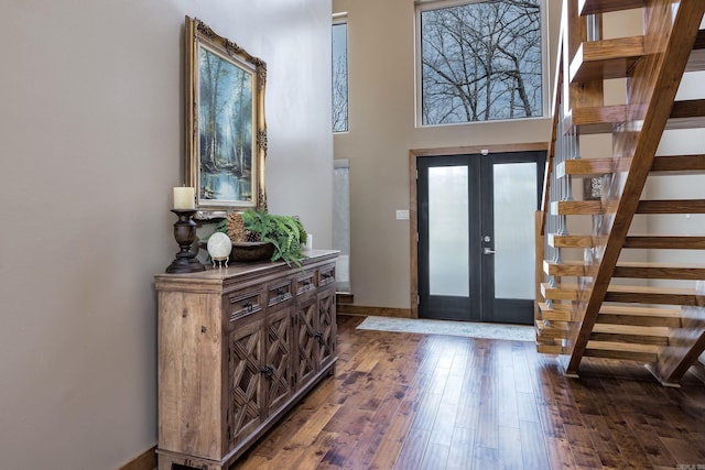 foyer featuring french doors, wood-type flooring, baseboards, and stairway
