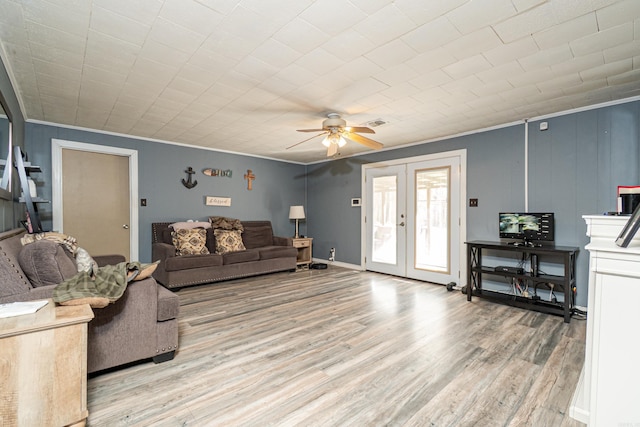 living room featuring crown molding, french doors, a ceiling fan, light wood finished floors, and visible vents