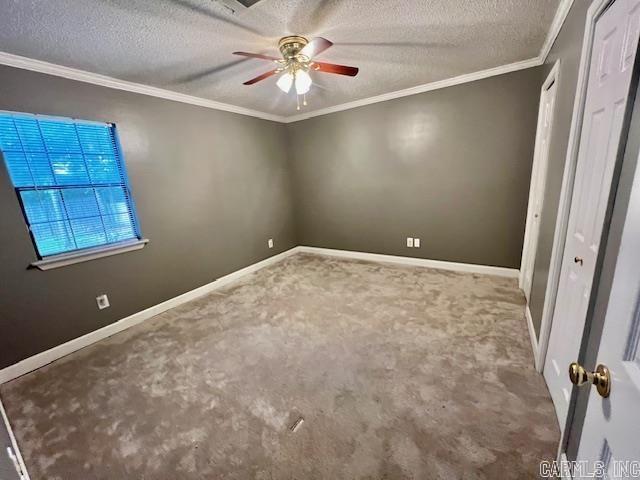unfurnished bedroom with baseboards, crown molding, carpet, and a textured ceiling