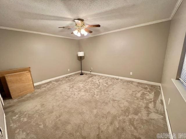 carpeted empty room with a ceiling fan, crown molding, baseboards, and a textured ceiling