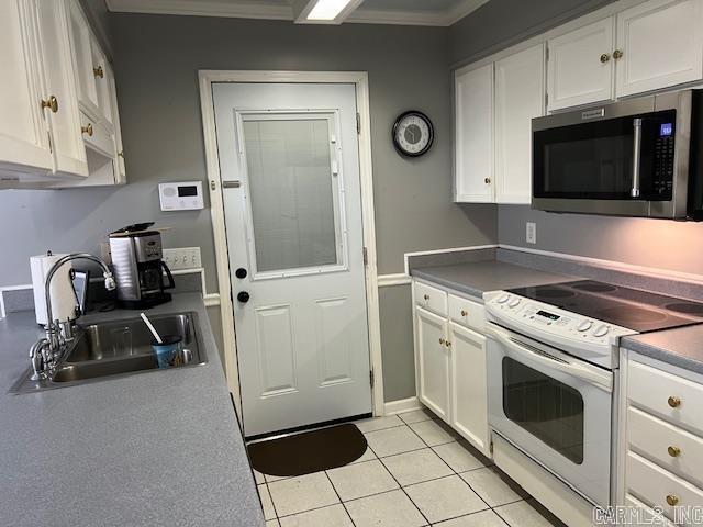 kitchen with light tile patterned flooring, stainless steel microwave, white cabinetry, a sink, and electric stove