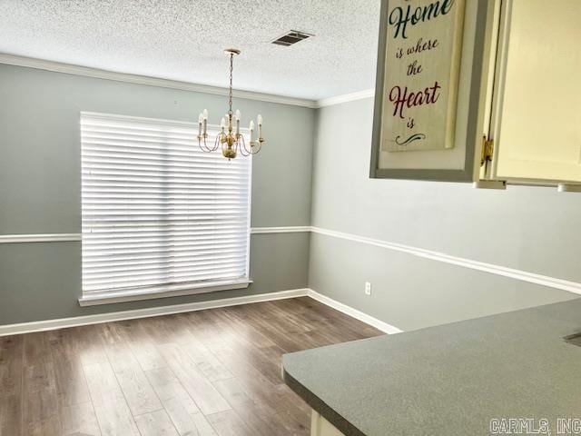 unfurnished dining area with visible vents, a notable chandelier, a healthy amount of sunlight, and dark wood finished floors
