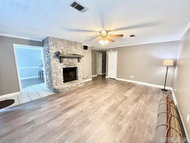 unfurnished living room with crown molding, visible vents, a ceiling fan, and wood finished floors