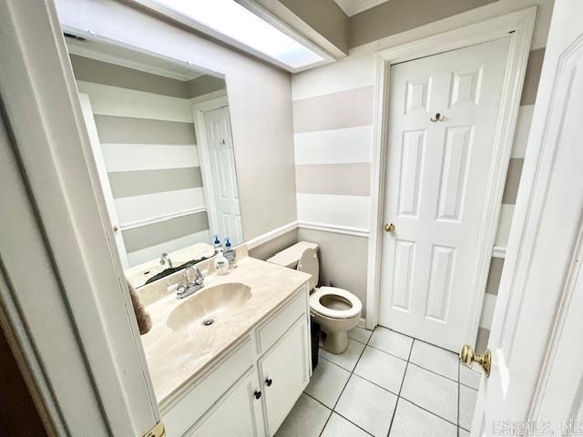 bathroom featuring toilet, tile patterned flooring, and vanity
