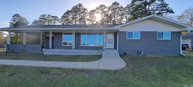 view of front of property featuring brick siding, a porch, crawl space, and a front lawn