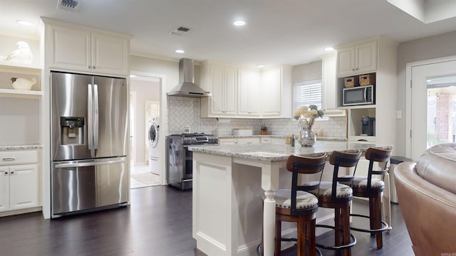 6006 Shadyside, Texarkana, TX 75503 - kitchen with backsplash, light stone counters, visible vents, appliances with stainless steel finishes, and wall chimney exhaust hood