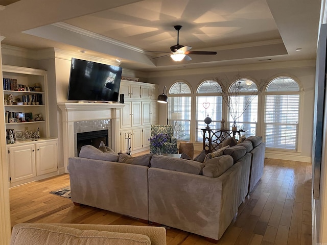 12706 Meadows Edge Ln, Little Rock, AR 72211 - living room with light wood-type flooring, ceiling fan, a tile fireplace, and a raised ceiling