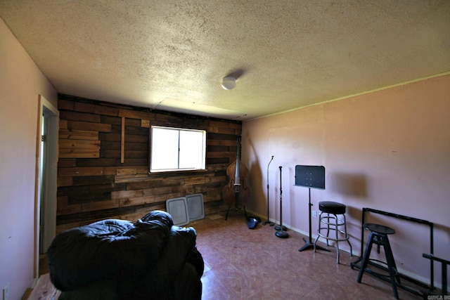 misc room featuring tile patterned floors, wood walls, and a textured ceiling