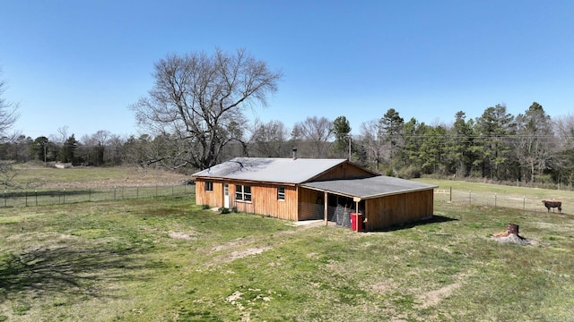 rear view of house featuring an outdoor structure, an exterior structure, and metal roof
