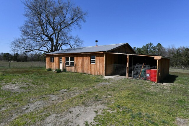 exterior space with metal roof, an outdoor structure, and an exterior structure