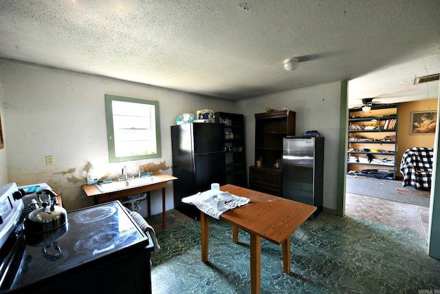 kitchen featuring a textured ceiling, visible vents, dark floors, a sink, and black appliances