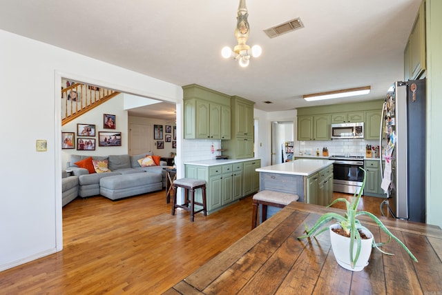 8 Allen Pt, Perryville, AR 72126 - kitchen with light countertops, light wood-type flooring, stainless steel appliances, visible vents, and green cabinetry