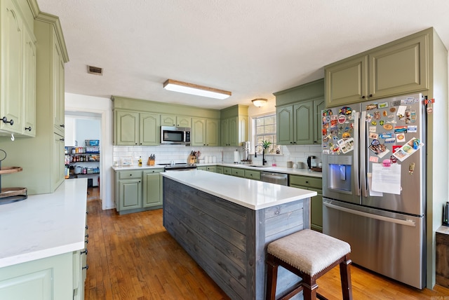 8 Allen Pt, Perryville, AR 72126 - kitchen with light countertops, stainless steel appliances, decorative backsplash, a sink, and green cabinetry